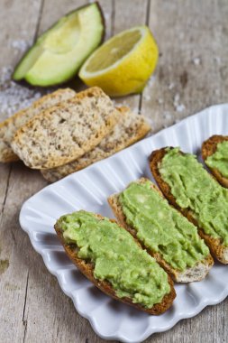 Beyaz plaka üzerinde avokado guacamole ile taze crostini 