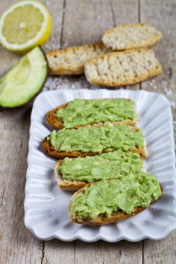 Beyaz plaka üzerinde avokado guacamole ile taze crostini 