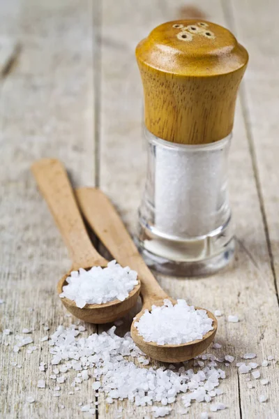 Wooden spoon with sea salt and cellar closeup on wooden rustic t — Stock Photo, Image
