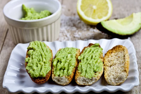 Crostini fresco com guacamole de abacate na placa branca closeup em — Fotografia de Stock