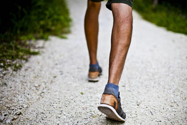 Vista de bajo ángulo del nivel del suelo con los pies de un hombre en el parque o el bosque —  Fotos de Stock