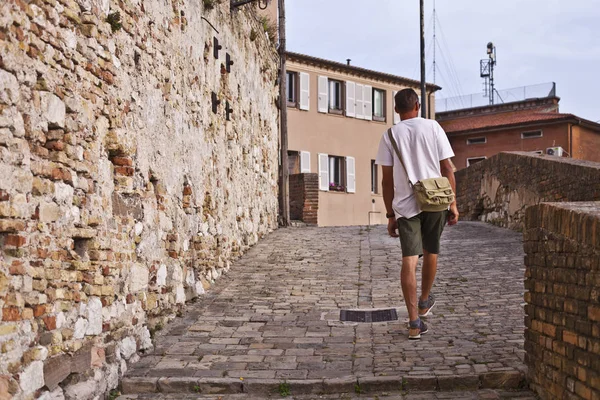 Вид ззаду на людину, яка гуляє в старовинному місті . — стокове фото