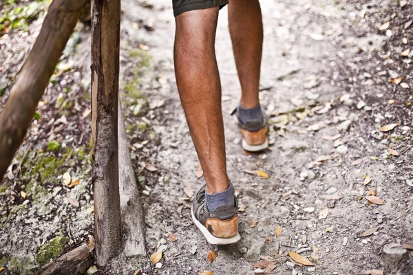 Las piernas del hombre en el parque o sendero forestal con pasamanos primer plano . — Foto de Stock