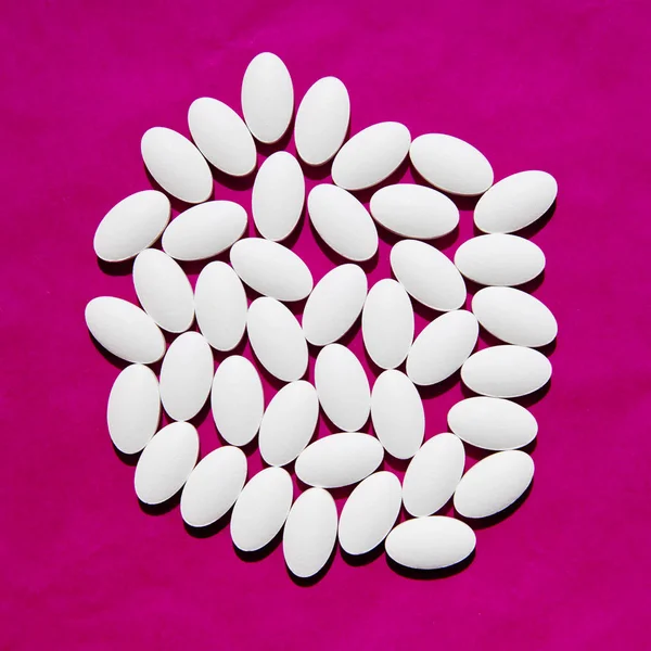 White pills group on magenta background. — 스톡 사진