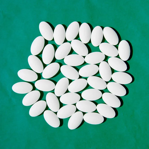 Група білих таблеток на зеленому фоні . — стокове фото