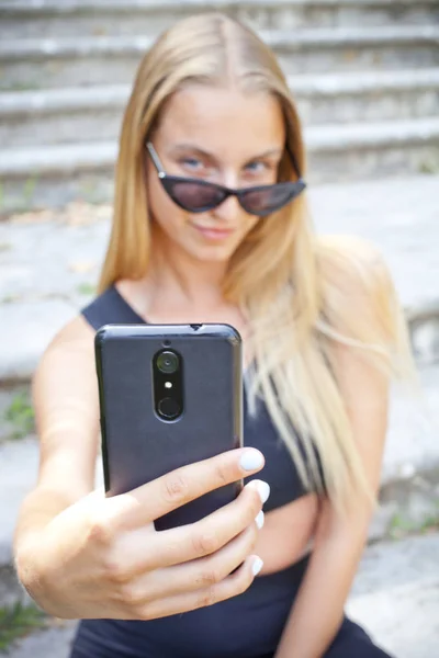 Atrakcyjna młoda kobieta w okularu do robienia selfie. — Zdjęcie stockowe