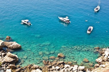 Tremiti Adaları manzarası. Kayalık bir kıyıya yakın tekneler. San Domino Adası, İtalya: çakırkeyif kayalık kıyı şeridinin manzaralı manzarası. Adriyatik Denizi. Puglia, İtalya.