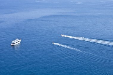 Adriyatik Denizi 'nin mavi berrak sularında yüzen teknelerin görüntüsü. Tremiti Adaları, İtalya.
