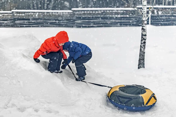 Twins Play Snowfall Time Inflatable Sledge Snow Tube Inner Tube — Stock Photo, Image