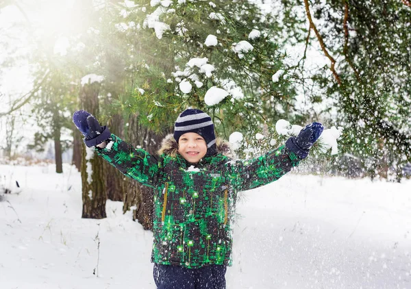 雪のシャワーの下で 年古い男の子のコスト 頭に松の枝に雪が飛行しています 冬のエンターテイメント — ストック写真