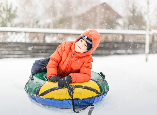 膨脹可能なそり 雪のチューブ インナー チューブを持つ少年にある雪の上 — ストック写真