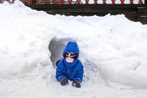 歳の男の子が雪の洞窟から外を見て — ストック写真