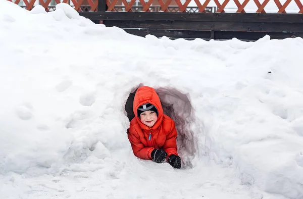 六岁的男孩从雪洞往外看 — 图库照片