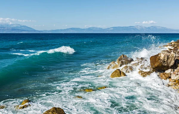 Corinthia. Korint Körfezi. Taşlar, dalgalar, su sıçramalarına.