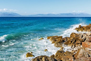 Corinthia. Korint Körfezi. Taşlar, dalgalar, su sıçramalarına.