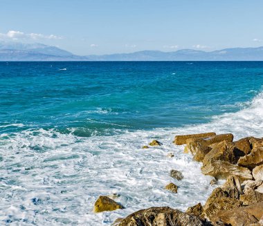 Corinthia. Korint Körfezi. Taşlar, dalgalar, su sıçramalarına.