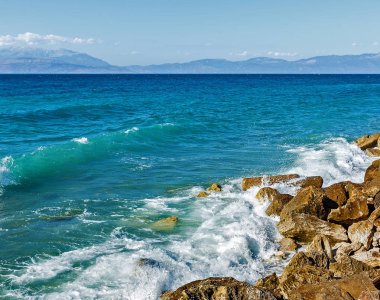 Corinthia. Korint Körfezi. Taşlar, dalgalar, su sıçramalarına.