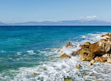 Corinthia. Korint Körfezi. Taşlar, dalgalar, su sıçramalarına.