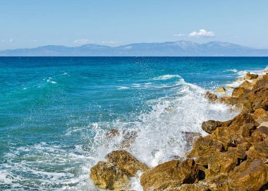 Corinthia. Korint Körfezi. Taşlar, dalgalar, su sıçramalarına.