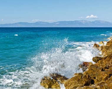 Corinthia. Korint Körfezi. Taşlar, dalgalar, su sıçramalarına.