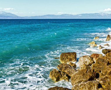 Corinthia. Korint Körfezi. Taşlar, dalgalar, su sıçramalarına.