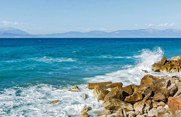 Corinthia. Korint Körfezi. Taşlar, dalgalar, su sıçramalarına.