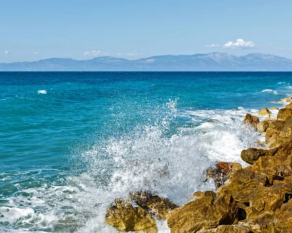 Corinthia. Korint Körfezi. Taşlar, dalgalar, su sıçramalarına.