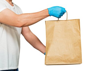 Eldivenli bir teslimatçı, kağıt torbası var. Beyaz arka planda izole edilmiş. Servis karantina pandemik koronavirüs virüsü konsepti.