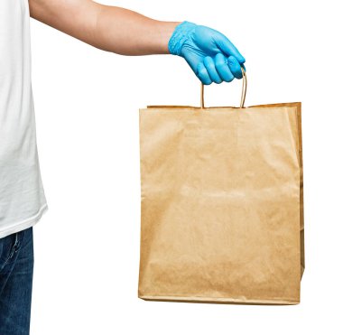 Eldivenli bir teslimatçı, kağıt torbası var. Beyaz arka planda izole edilmiş. Servis karantina pandemik koronavirüs virüsü konsepti.