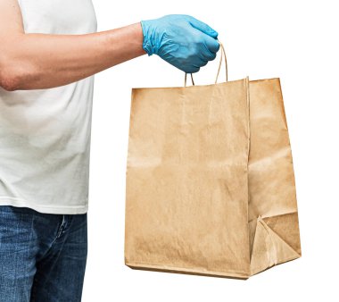 Eldivenli bir teslimatçı, kağıt torbası var. Beyaz arka planda izole edilmiş. Servis karantina pandemik koronavirüs virüsü konsepti.