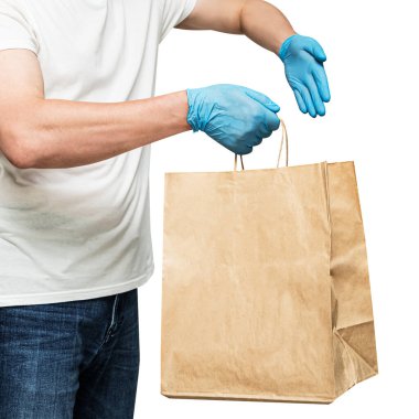 Eldivenli bir teslimatçı, kağıt torbası var. Beyaz arka planda izole edilmiş. Servis karantina pandemik koronavirüs virüsü konsepti.