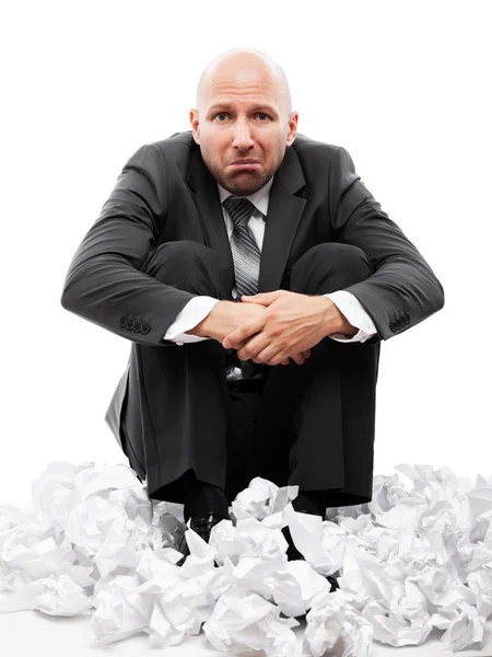 Affärsman i depression sitter på skrynkliga rivna pappersdokument — Stockfoto
