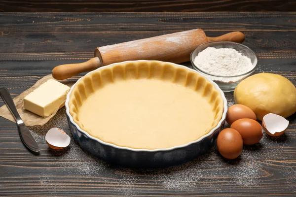 Massa de pão curto para assar torta de quiche e ingredientes em forma de cozimento — Fotografia de Stock