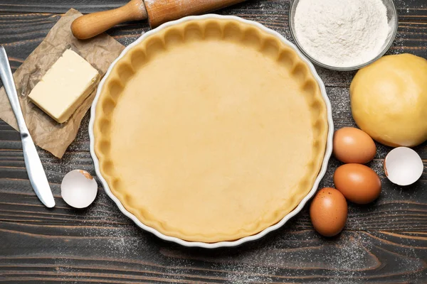 Pâte sablée pour faire cuire la tarte à la quiche et les ingrédients sous forme de cuisson — Photo