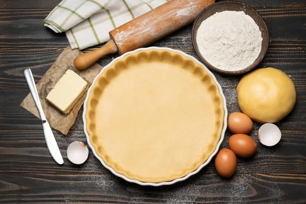 Pâte sablée pour faire cuire la tarte à la quiche et les ingrédients sous forme de cuisson — Photo