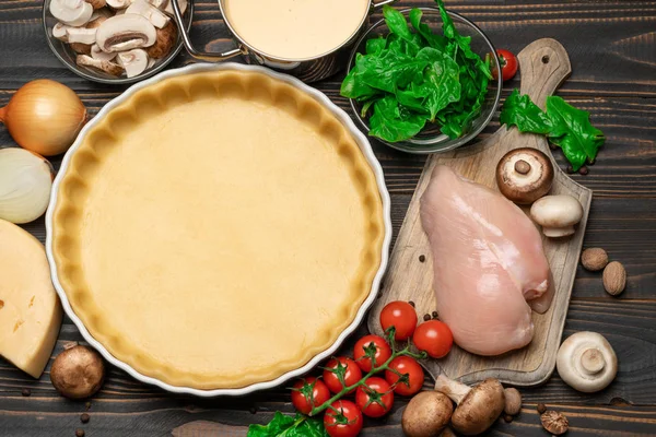 Pâte sablée pour faire cuire la tarte à la quiche et les ingrédients sous forme de cuisson — Photo