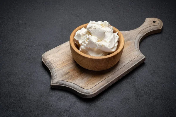 Традиційний сир маскарпоне в дерев'яній мисці на бетонному фоні — стокове фото