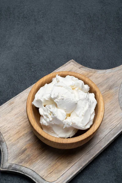 Traditionella Mascarpone ost i trä skål på konkreta bakgrund — Stockfoto