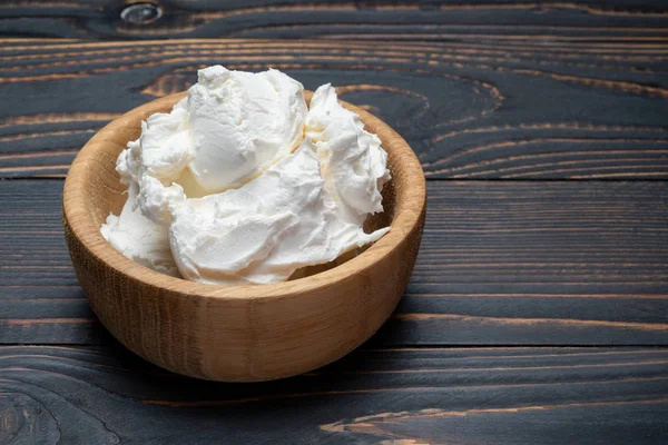 Queijo Mascarpone tradicional em tigela de madeira na mesa — Fotografia de Stock