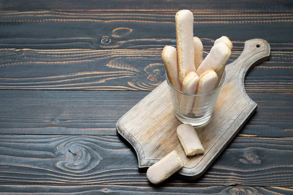 Galletas tradicionales italianas Savoiardi ladyfingers en vidrio sobre fondo de madera —  Fotos de Stock