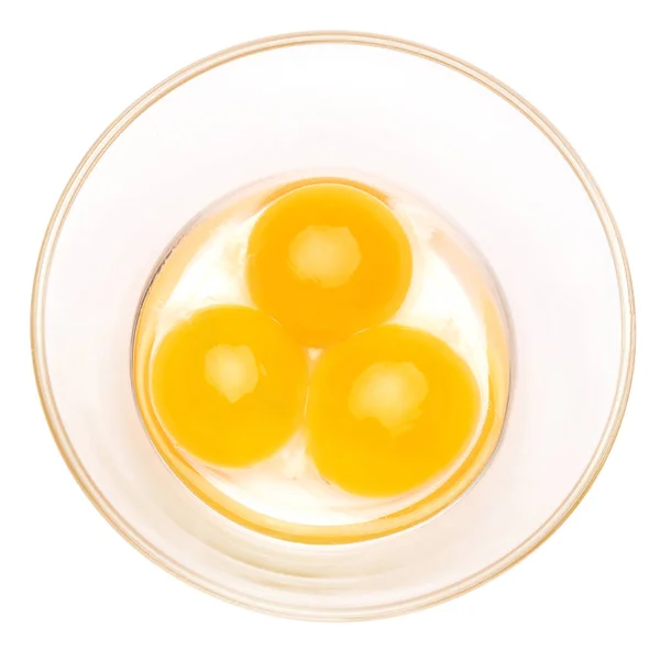 Три яєчні жовтки в скляній мисці ізольовані на білому тлі з відсічним контуром — стокове фото