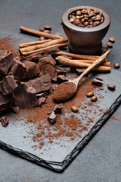 Piezas de chocolate orgánico oscuro o lácteo y cacao en polvo sobre fondo de hormigón oscuro — Foto de Stock