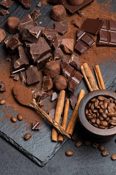 Ciemne lub mleko organiczne kawałki czekolady i kakao w proszku na ciemnym betonie upierzenie — Zdjęcie stockowe