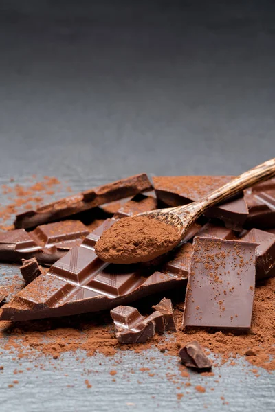 Donkere of melk biologische chocolade stukken en cacaopoeder op donkere betonnen backgound — Stockfoto