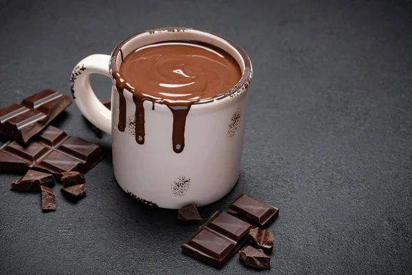 Kupa forró csokoládé és darabok csokoládé sötét beton háttér — Stock Fotó