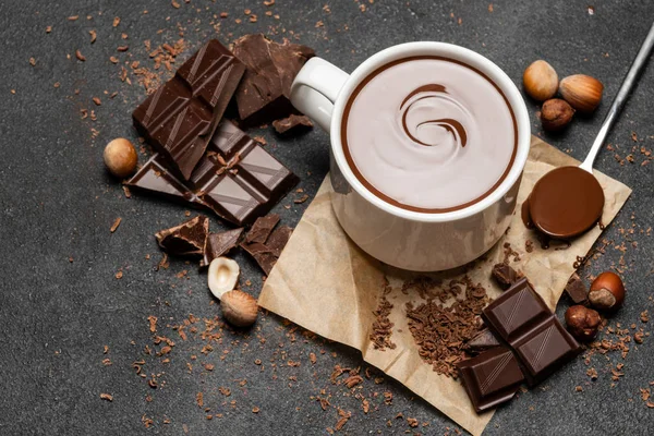 Copo de chocolate quente e pedaços de chocolate no fundo de concreto escuro — Fotografia de Stock