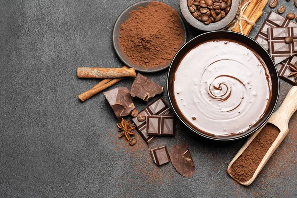 Tigela cerâmica de creme de chocolate ou chocolate derretido e pedaços de chocolate isolado em fundo de concreto escuro — Fotografia de Stock