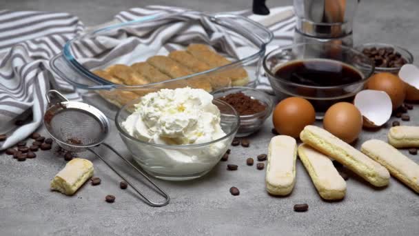 Ingrediënten voor het maken van traditionele Italiaanse taart tiramisu op betonnen tafel — Stockvideo