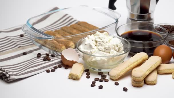 Ingrediënten voor het maken van traditionele Italiaanse taart tiramisu op witte achtergrond — Stockvideo