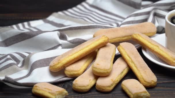 Italiano Savoiardi ladyfingers Galletas y taza de café sobre fondo de madera — Vídeos de Stock